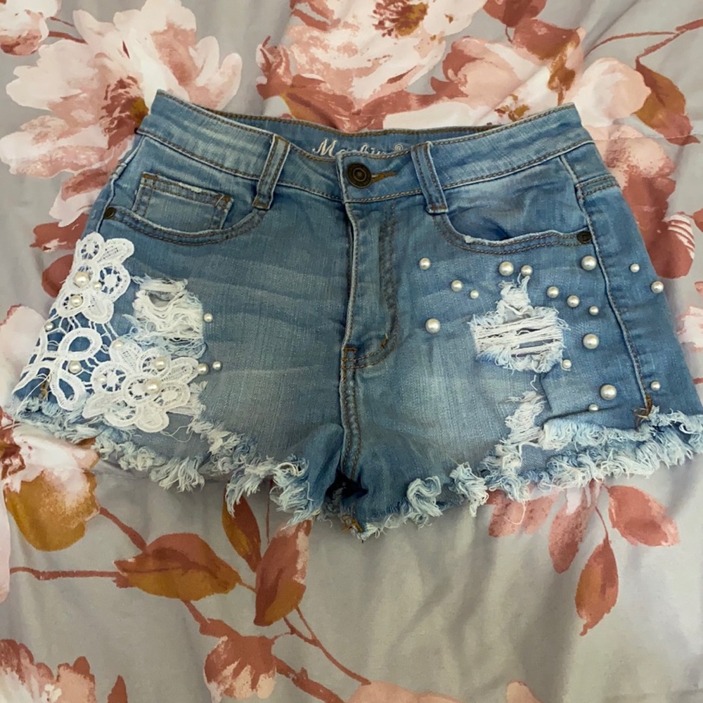 Blue denim short with designs on the sides. Size 26, high waisted and short.
